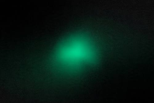 Deep dark gradient with a single glowing emerald light bloom, moody minimal abstract background, subtle grain
